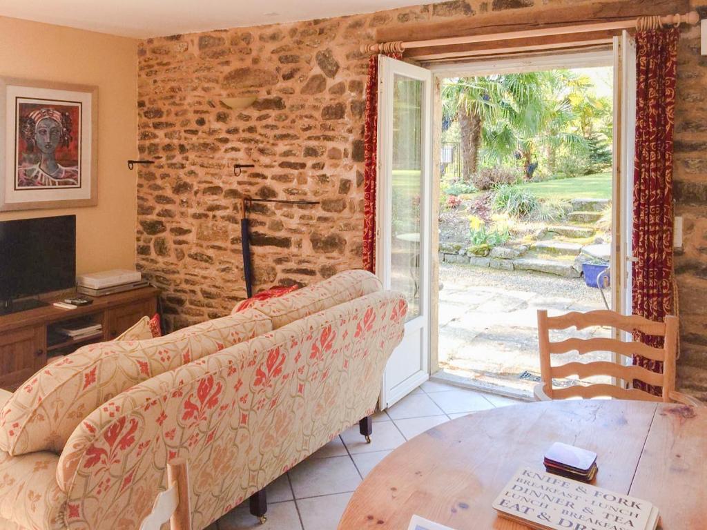 ein Wohnzimmer mit einem Sofa und einem Tisch in der Unterkunft Val Rive - Degas Apartment in Dinan