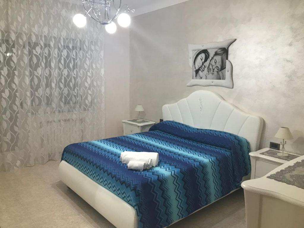 ein Schlafzimmer mit einem Bett mit einer blauen Bettdecke in der Unterkunft Taras holiday house in Taranto