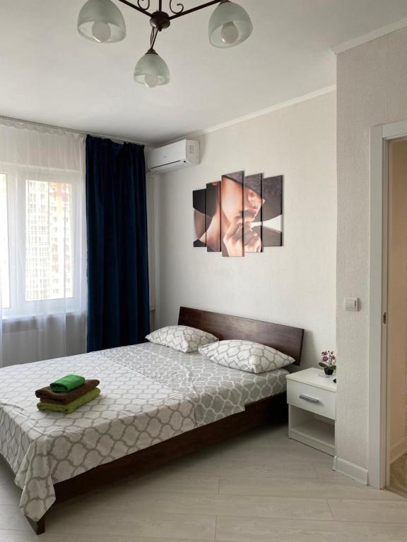 Cozy Apartment on Gmyri 12b near metro Poznyaki في كييف: غرفة نوم بسرير ومروحة سقف