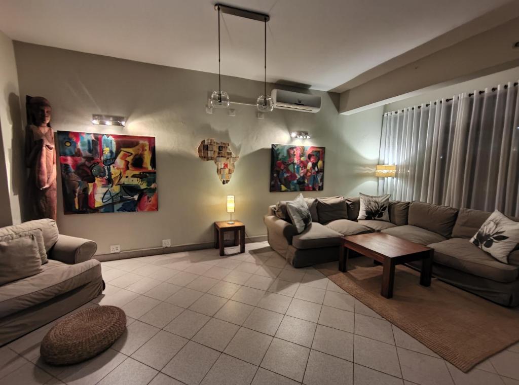 uma sala de estar com dois sofás e uma mesa em Sundown Guest House Maputo em Maputo
