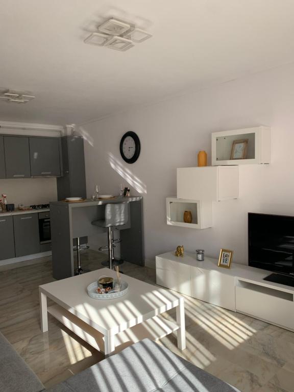 - un salon blanc avec une table et une télévision dans l'établissement Complex Rezidential Ana, à Caransebeş