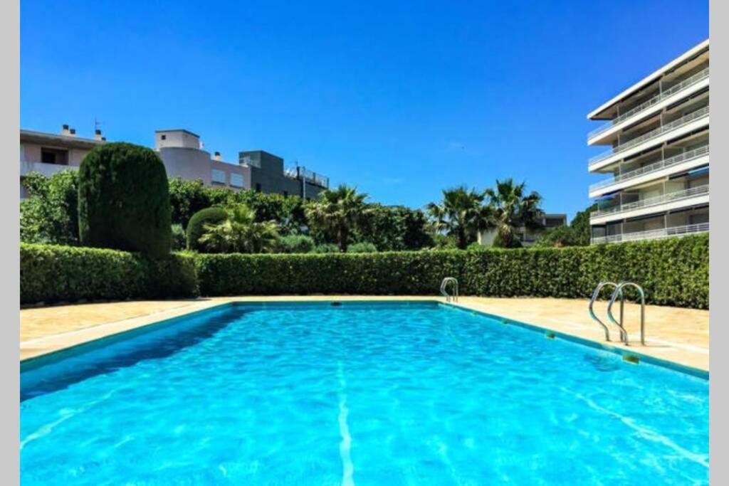 a large blue swimming pool in front of a building at F2 Climatisé Piscine Proche Plage in Cavalaire-sur-Mer