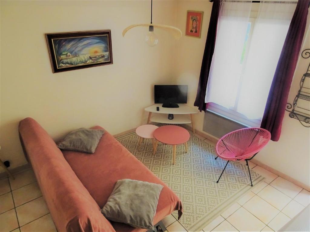 a living room with a couch and a table at Maison De Village in Saint-Raphaël