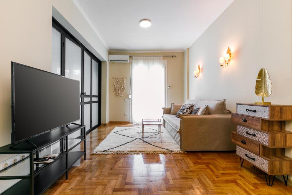 een woonkamer met een bank en een flatscreen-tv bij NEW LUXURY CENTRAL BOUTIQUE in Thessaloniki