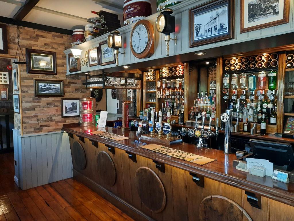 a bar with a counter and a clock on the wall at The Labouring Man in Coldwaltham