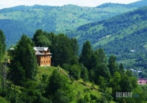 a house on top of a hill with trees at Садиба Лісовичок in Yaremche
