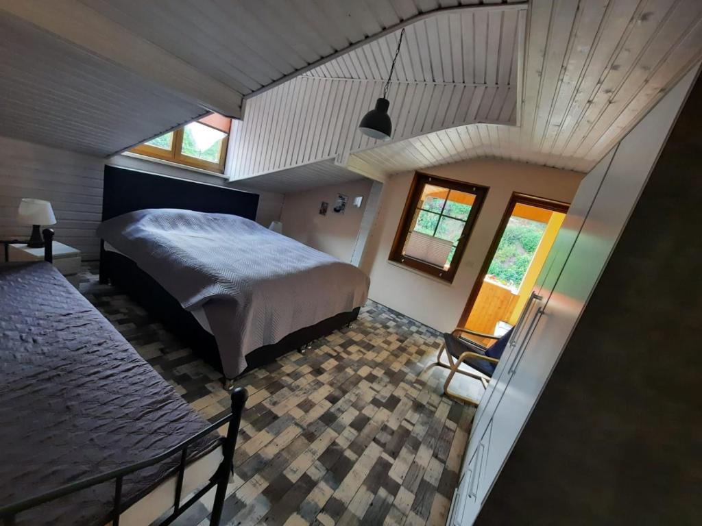 a bedroom with a bed and a chair in a room at Ferienhaus Waterstrat in Stolberg i. Harz