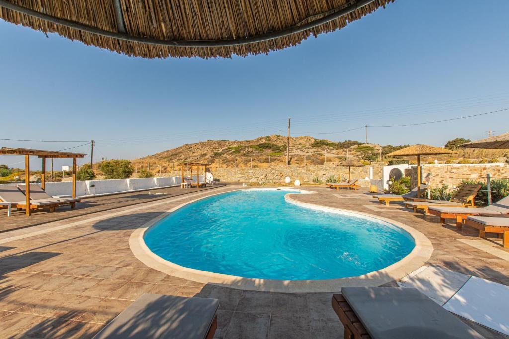 una piscina in un resort con tavoli e sedie di Delight Apartments suites a Stelida