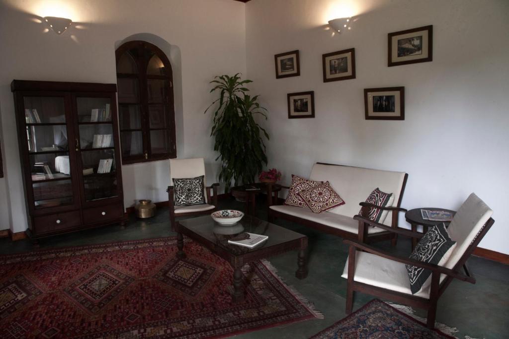 Una sala de estar con un sofá y sillas y una mesa. en Hiliki House, en Zanzíbar