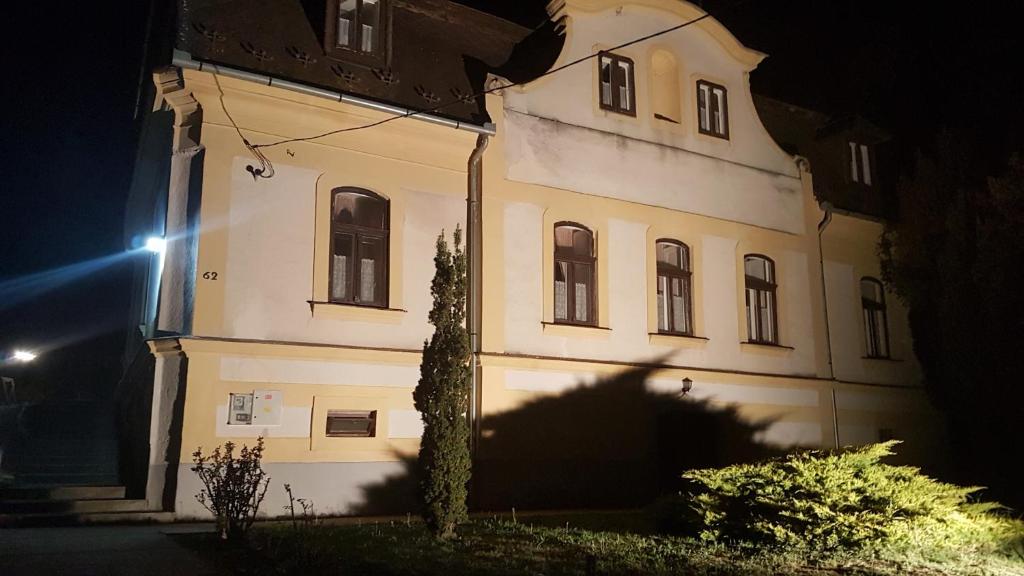 a building with a tree in front of it at night at Brezovay Kastély Panzió in Egerszólát