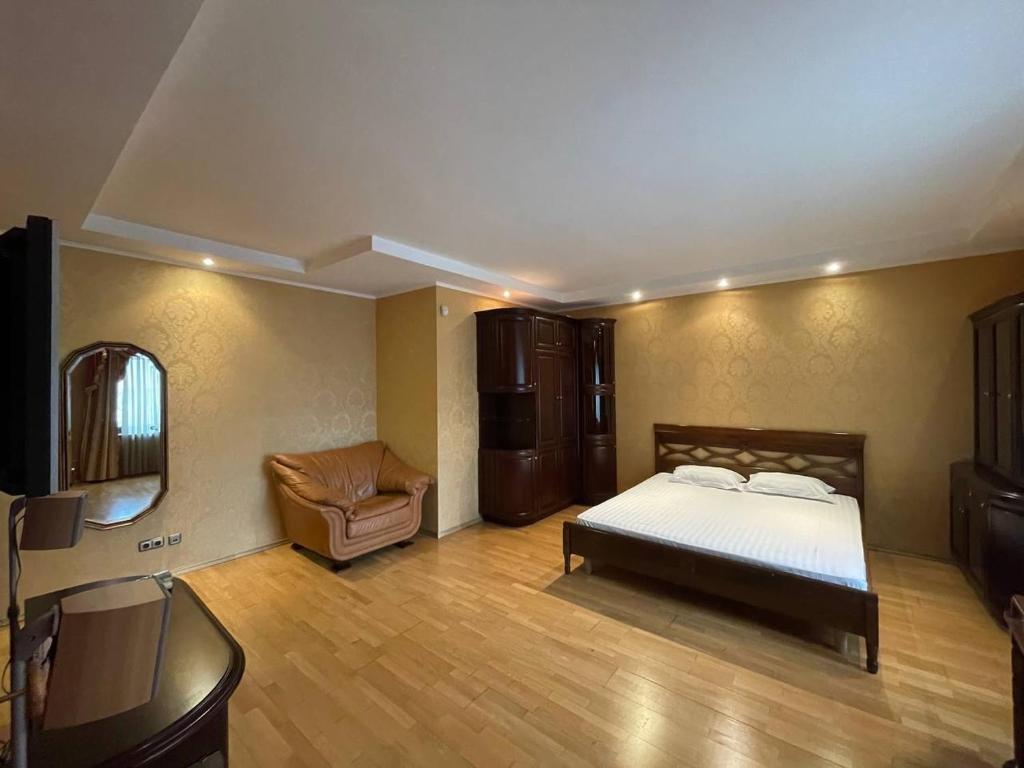 ein Schlafzimmer mit einem Bett und einem Stuhl in der Unterkunft One bedroom Kreschatik Str 4 in Kiew