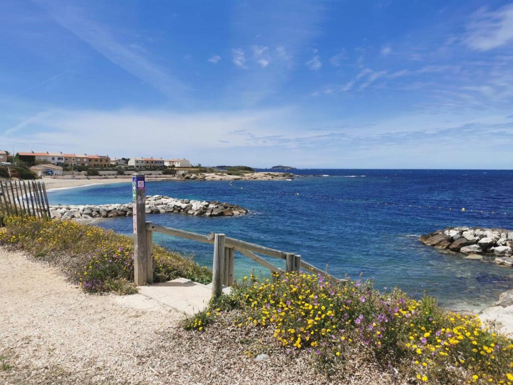 - une plage avec une clôture en bois et l'océan dans l'établissement T2 Six-fours chez Anne et Ollivier, à Six-Fours-les-Plages