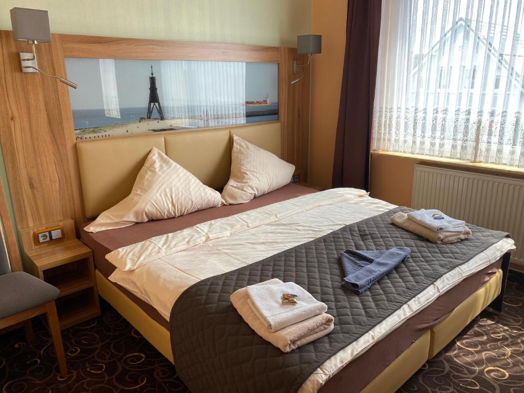 a hotel room with a bed with towels on it at Gästehaus Seestern in Cuxhaven