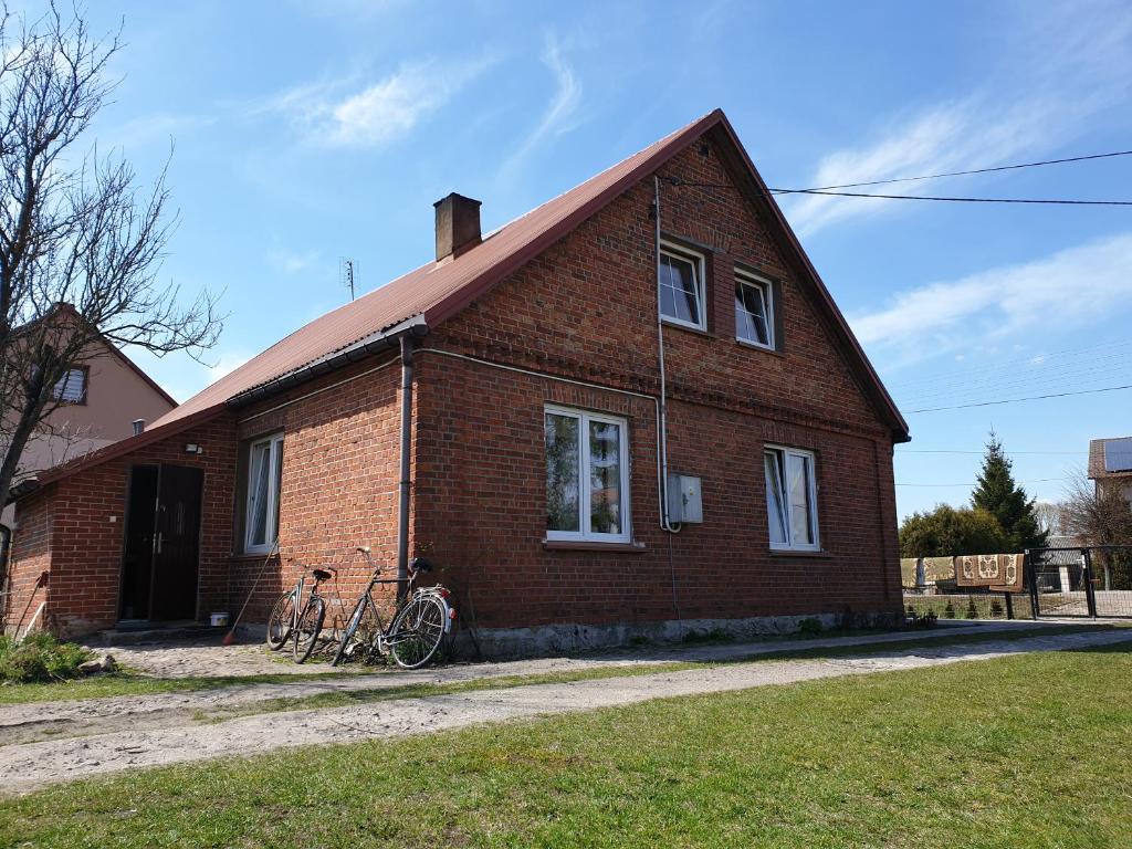 KleszczeleにあるKwatera27の外に自転車を停めたレンガ造りの家