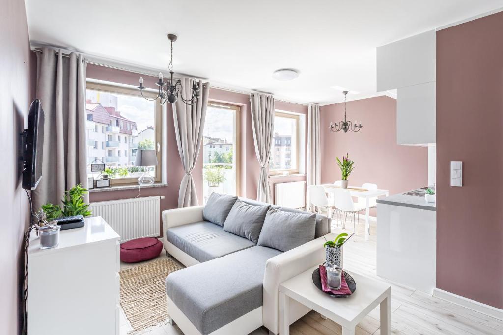 a living room with a couch and a kitchen at Apartament "Anna" - Kwartał Róży Wiatrów, 15 min spacerem od plaży in Świnoujście