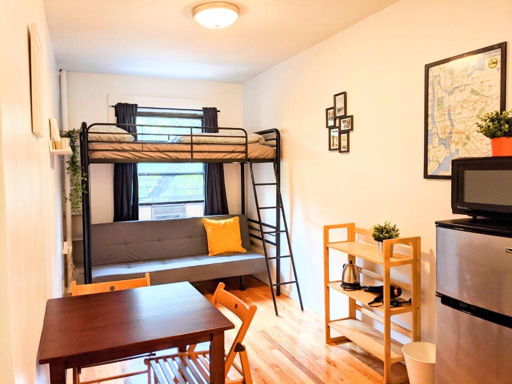 - une chambre avec des lits superposés, une table et une salle à manger dans l'établissement The VILLAGE HOUSE NYC, à New York