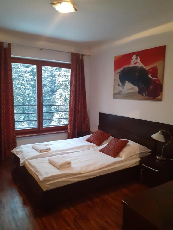 sypialnia z łóżkiem i dużym oknem w obiekcie Apartament Hiszpański w Zakopanem