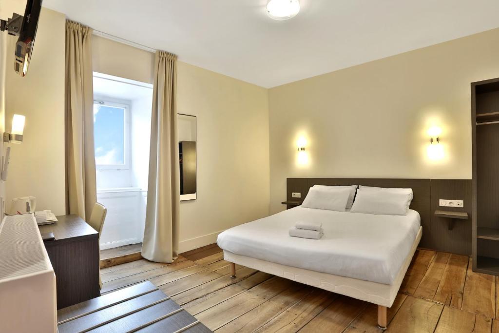 Postel nebo postele na pokoji v ubytování Logis Hotel Auberge Dupuytren