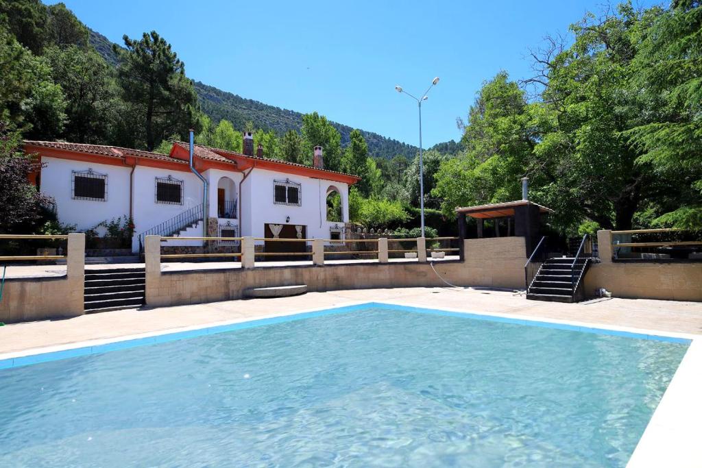a house with a swimming pool in front of a house at VILLA FORASTERA in Arroyo Frio