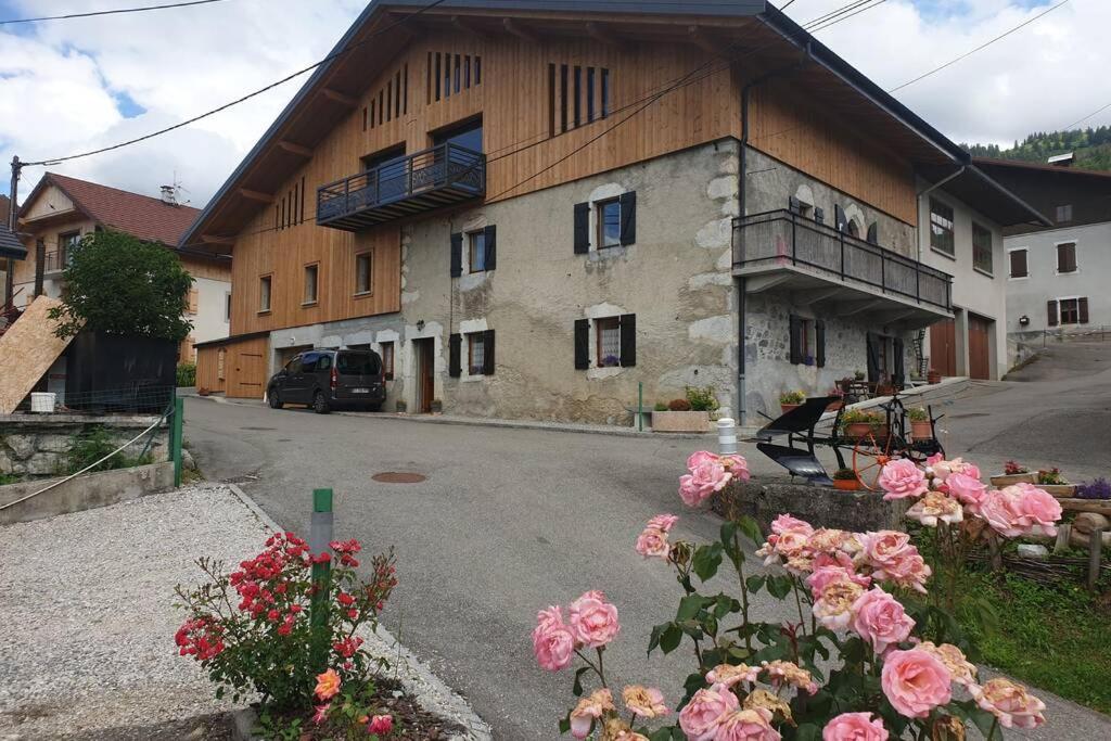a large building with flowers in front of it at Villard au cœur de la vallée verte entre lac et montagne in Villard-sur-Boëge