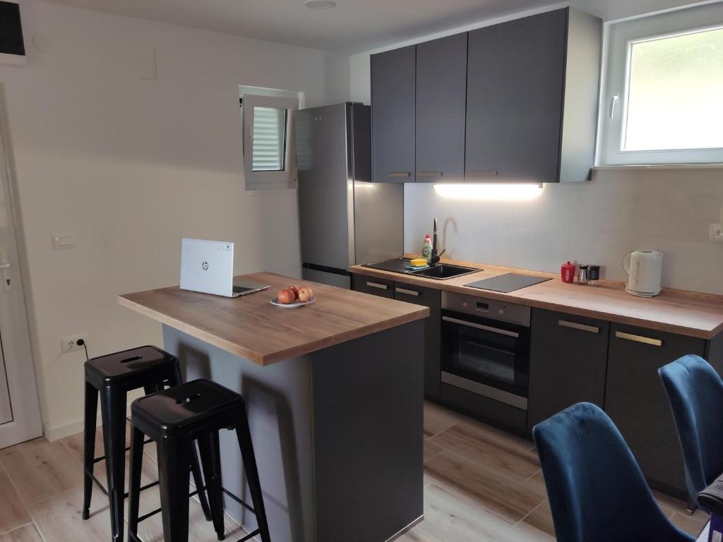 a kitchen with black cabinets and a counter with stools at Apartment Varga in Sveti Juraj