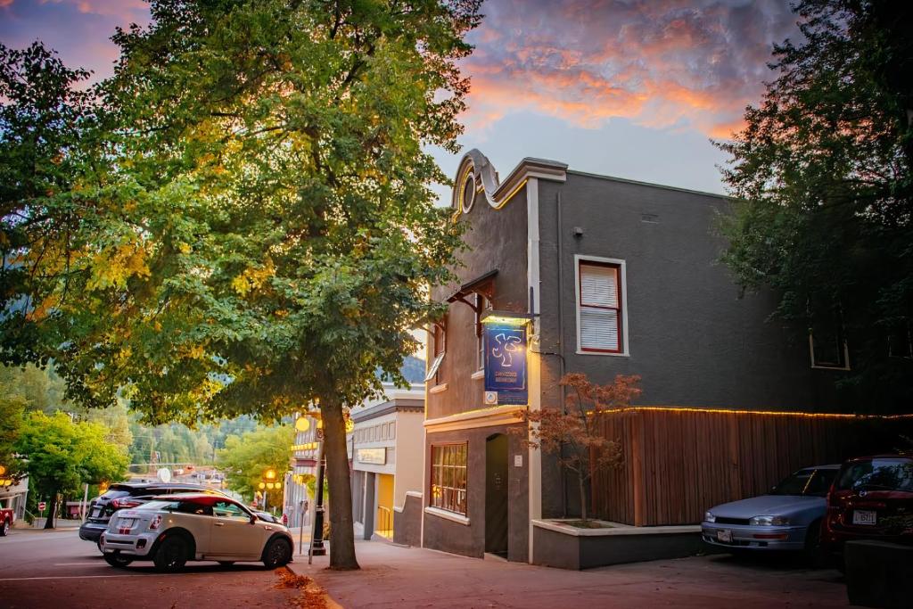 un coche aparcado frente a un edificio en una calle en Dancing Bear Inn Hostel en Nelson