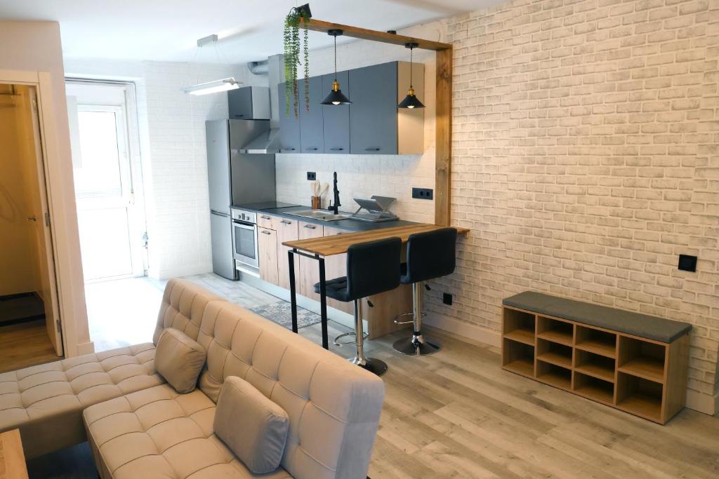 Rita, apartament ideal per a dos في تريمب: غرفة معيشة مع أريكة وجدار من الطوب