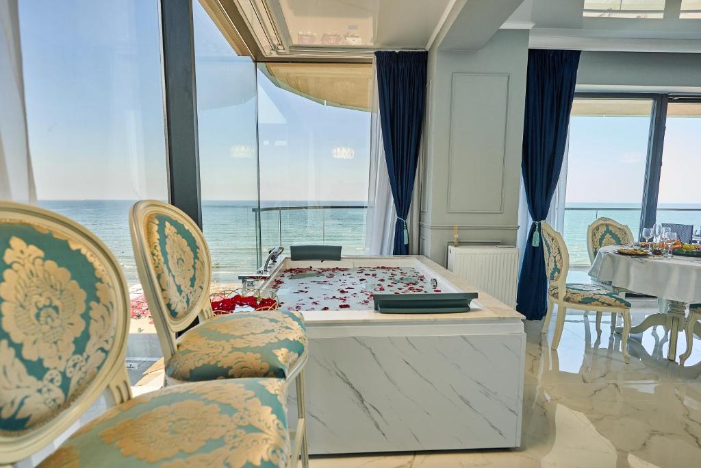 um quarto com uma mesa e cadeiras e uma mesa e uma mesa e uma espreguiçadeira em Luxury by the sea, Mamaia em Năvodari