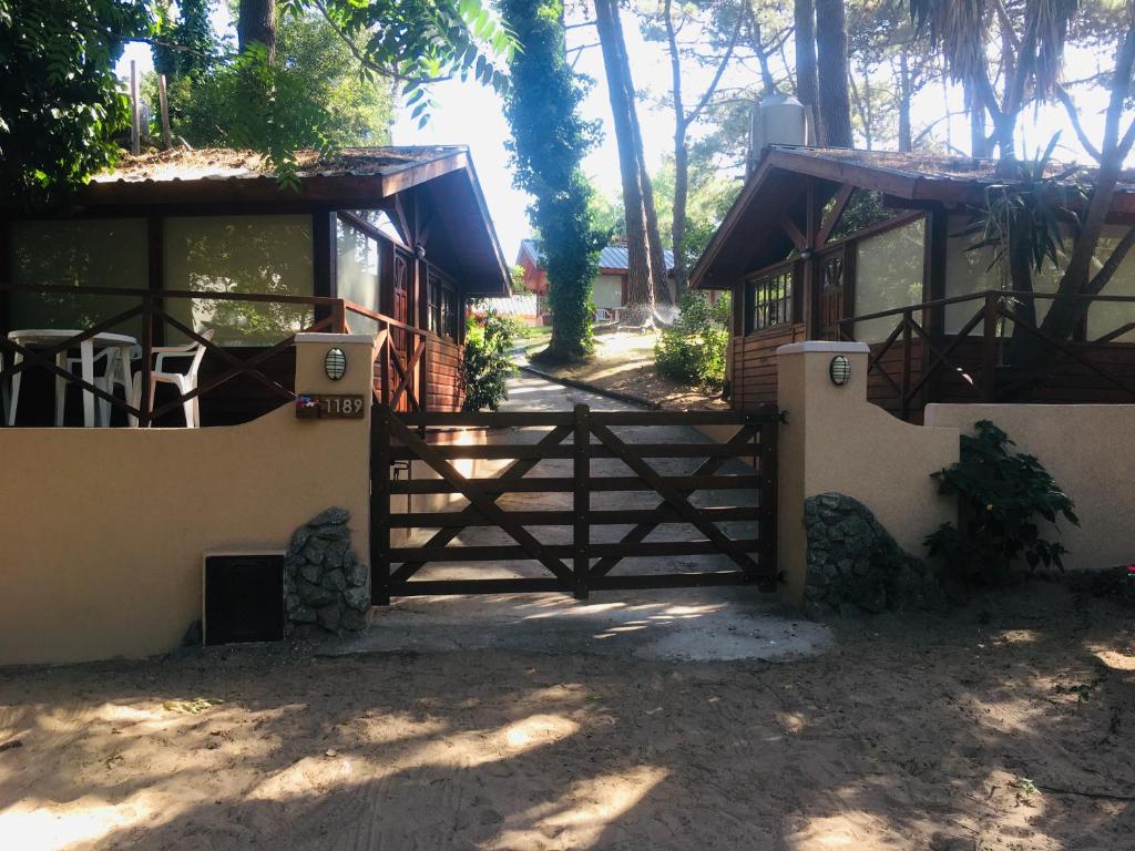 una puerta frente a una casa con árboles en Cabañas Entre Pinos en Villa Gesell