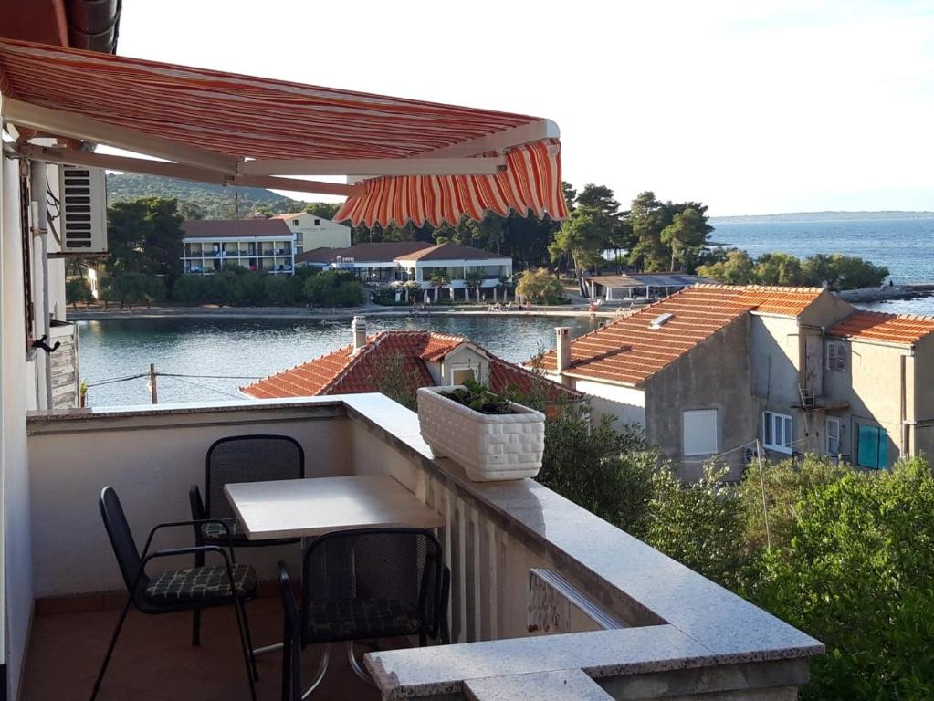 a balcony with a table and chairs and a view of the water at Apartman 2 -NENA- in Zadar