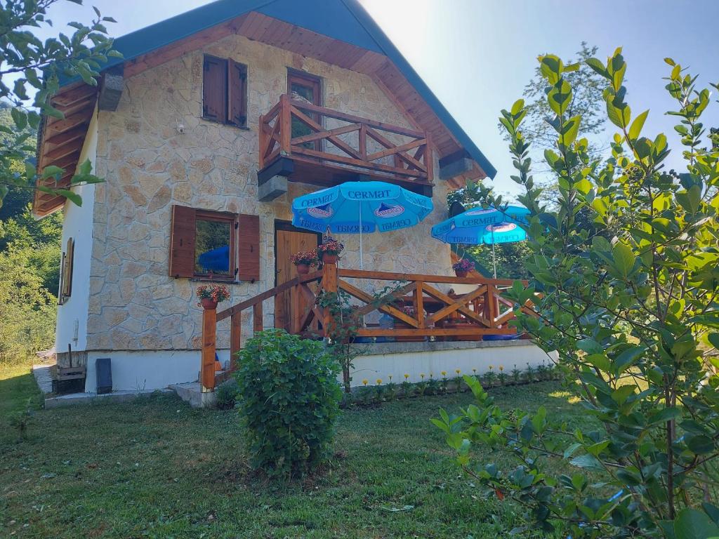 dom z dwoma niebieskimi parasolami przed nim w obiekcie Vila Verusa w mieście Veruša