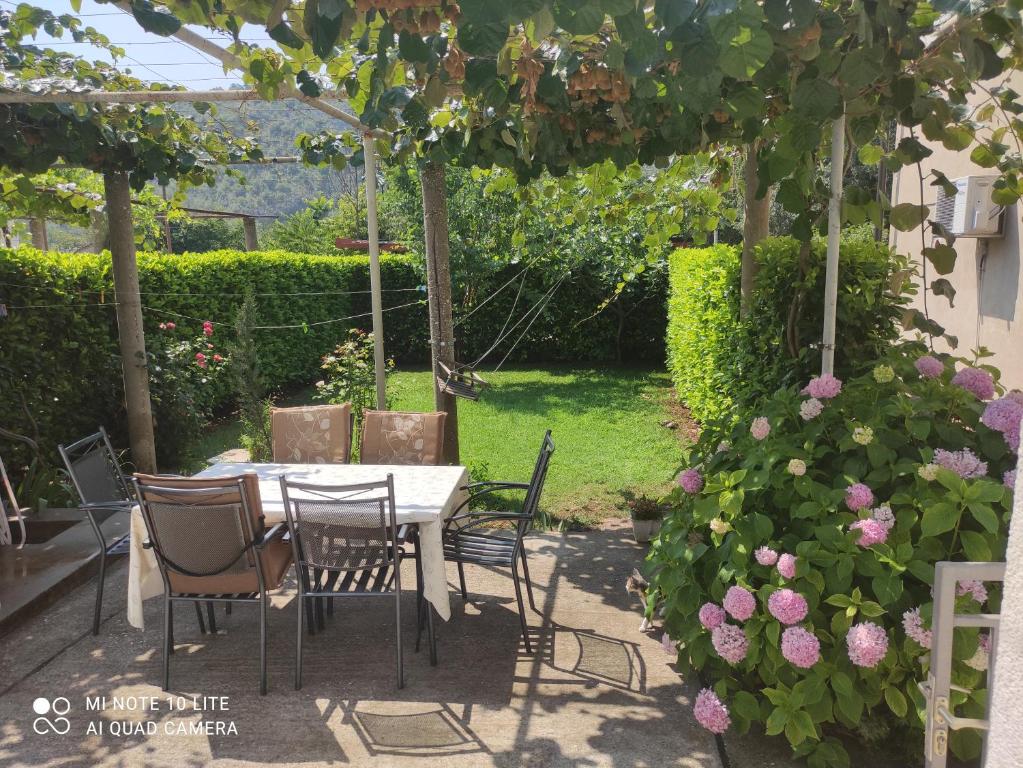 a table and chairs in a garden with roses at Vacation Home Katarina in Čapljina