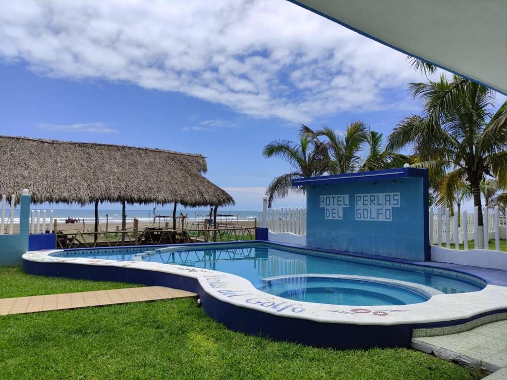 uma piscina num resort com o oceano ao fundo em Hotel Perlas del Golfo em Chachalacas