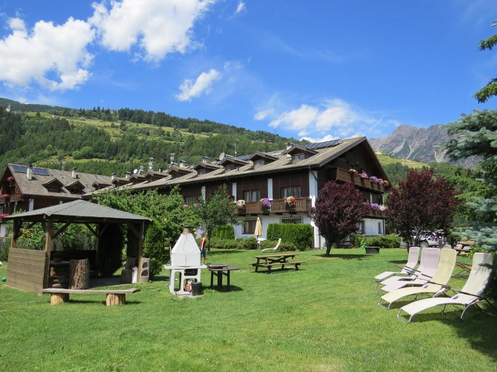 a building with chairs and a picnic table in the yard at lareit appartamenti in Bormio