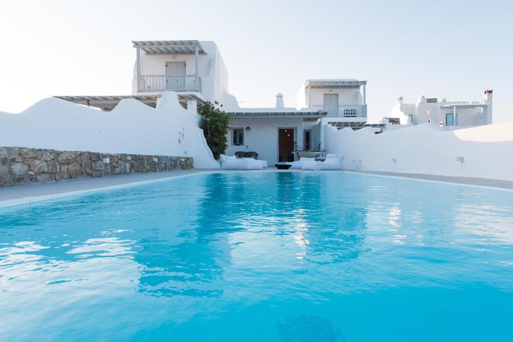 a swimming pool with blue water in front of white buildings at MarLeon in Kalo Livadi