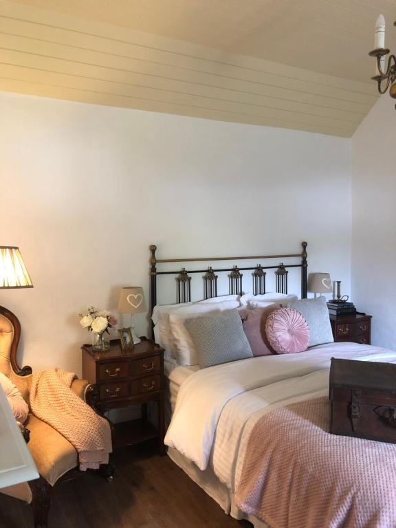 um quarto com uma cama grande e piso em madeira em Keenaghan Cottage Belleek em Belleek