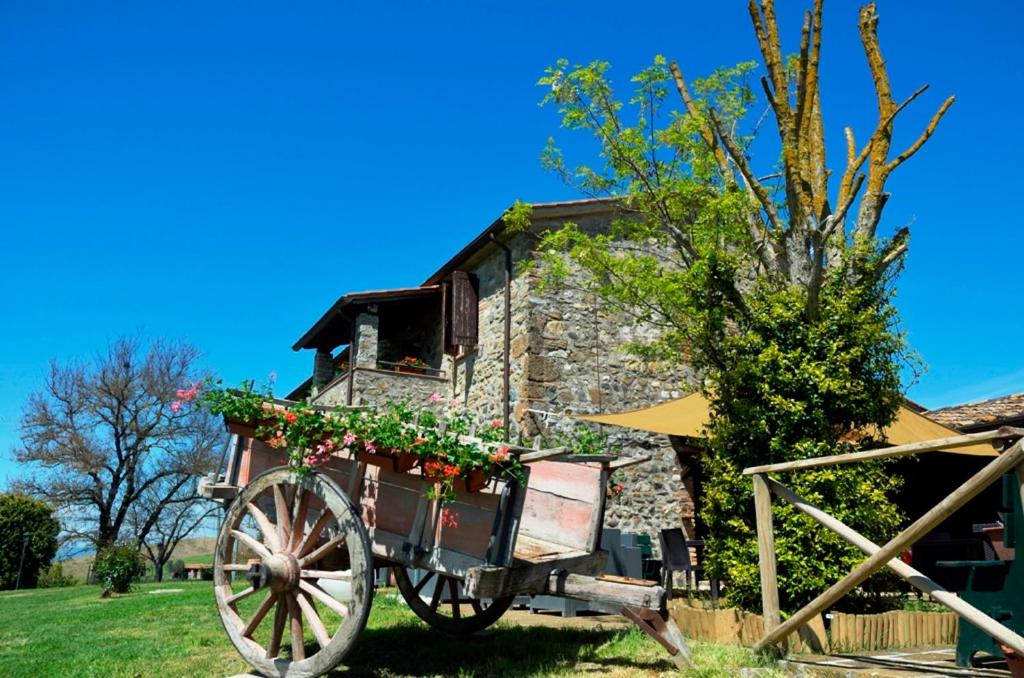 una casa in pietra con carrozza trainata da cavalli di Agriturismo Il Poggio Di Orvieto a Orvieto