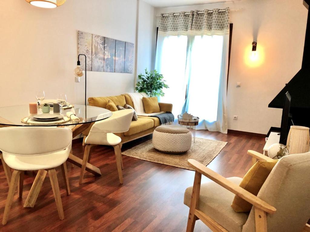 a living room with a table and a couch at Cal Xera - Acollidora planta baixa amb jardí privat i llar de foc in Puigcerdà