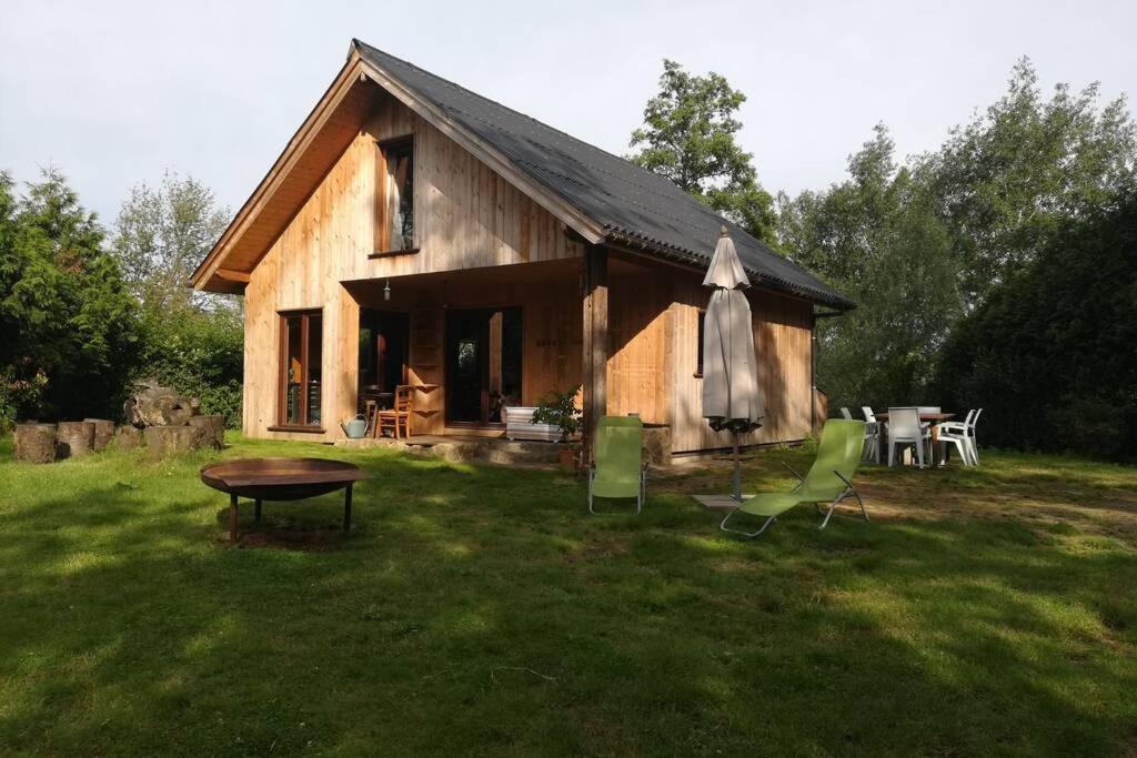 une maison en bois avec une table et des chaises dans la cour dans l'établissement Le chalet des carrières, à Chastre-Villeroux-Blanmont