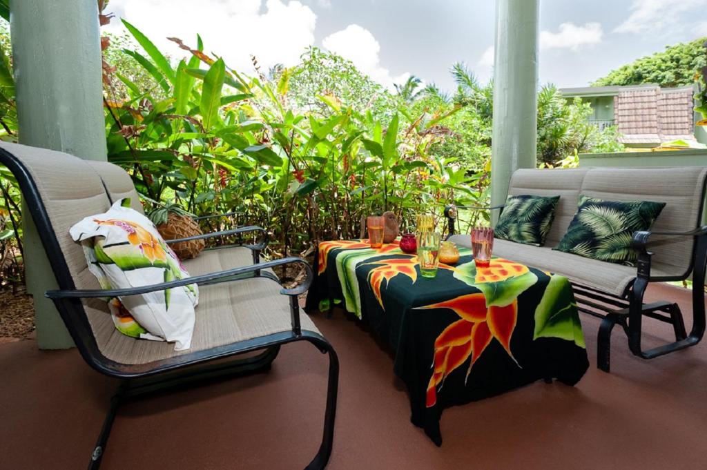 une terrasse couverte avec une table et des chaises. dans l'établissement Puamana 25B, à Princeville