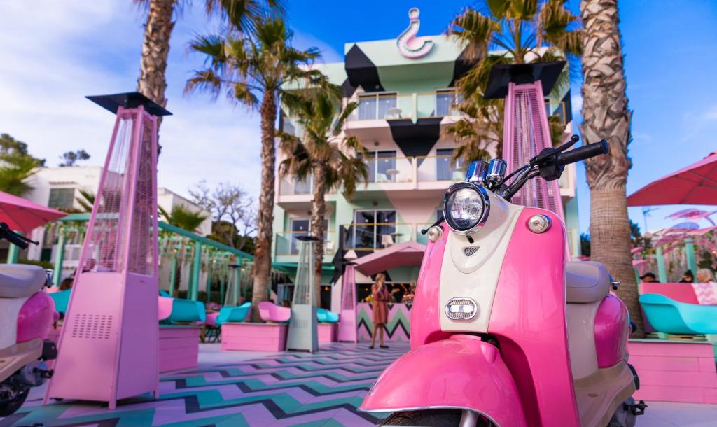 een roze scooter geparkeerd voor een hotel bij Apartamentos Wi-Ki-Woo in San Antonio