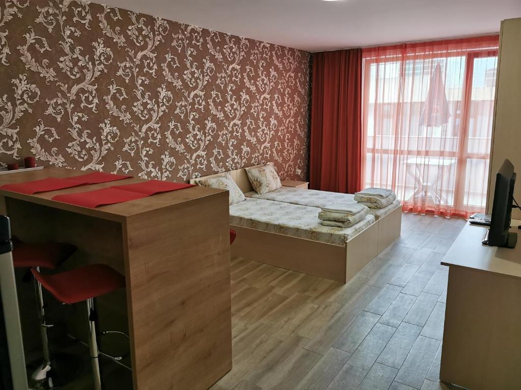 a room with a bed and a desk in it at Apartment Kraev in Primorsko
