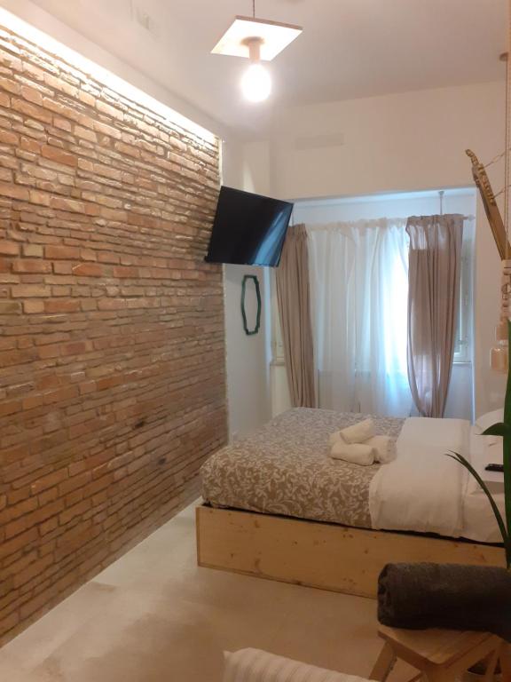 een slaapkamer met een bakstenen muur en een bed bij arco del sacramento casa vacanze in Benevento