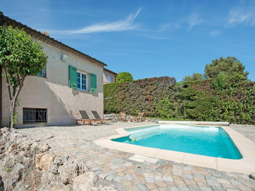 a swimming pool in a yard next to a house at Holiday home in La Roquette sur Siane with furnished garden in La Roquette-sur-Siagne