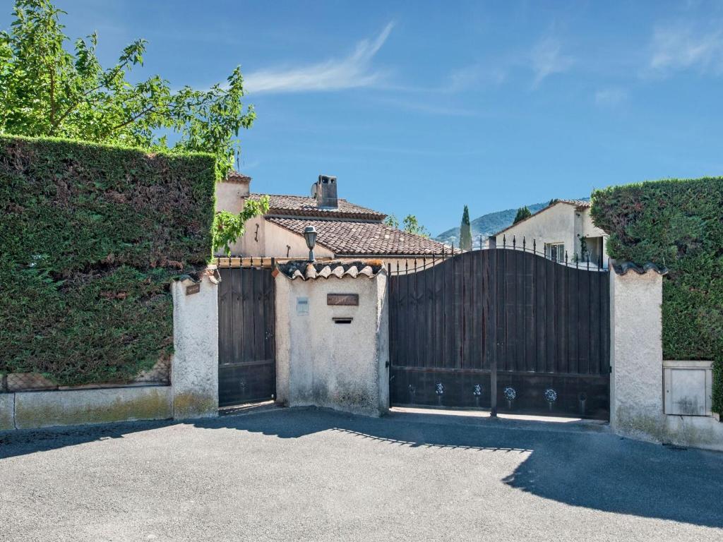 a gate to a house with a wooden fence at Holiday home in La Roquette sur Siane with furnished garden in La Roquette-sur-Siagne
