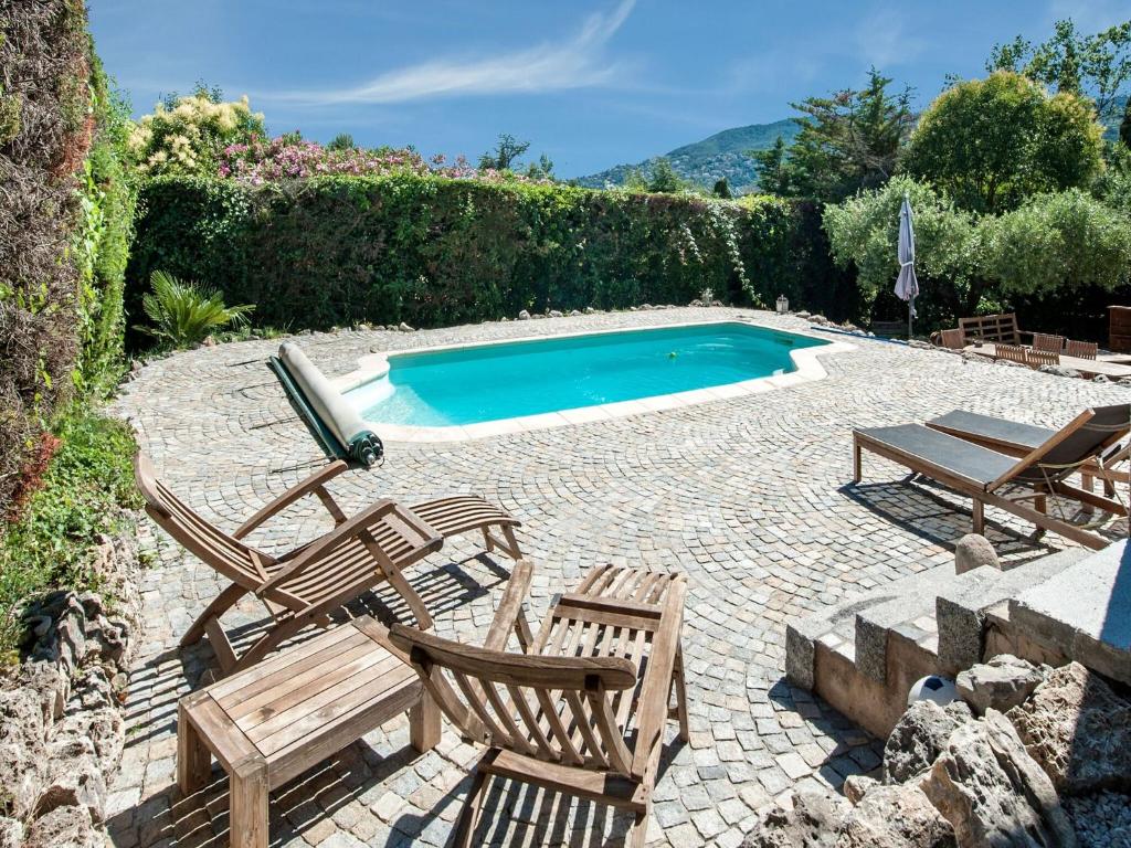 un patio con sillas y una piscina en Holiday home in La Roquette sur Siane with furnished garden, en La Roquette-sur-Siagne