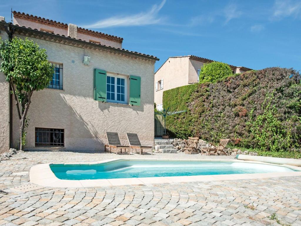 a swimming pool in front of a house at Holiday home in La Roquette sur Siane with furnished garden in La Roquette-sur-Siagne