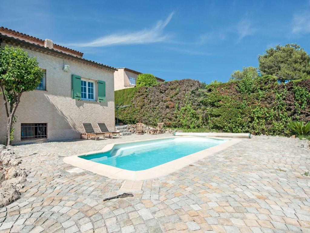 a swimming pool in front of a house at Holiday home in La Roquette sur Siane with furnished garden in La Roquette-sur-Siagne