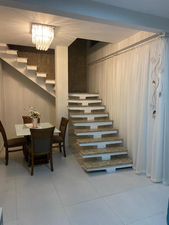 una escalera en una habitación con mesa y sillas en ASP hospedaria, en Paranaguá