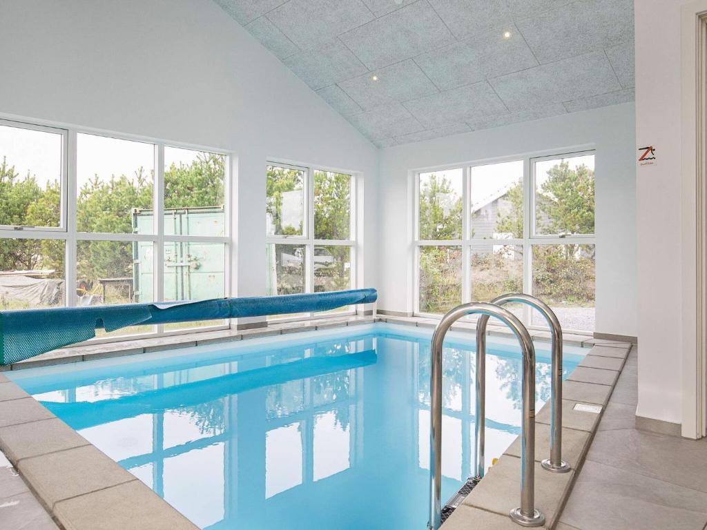 una piscina de agua azul en una habitación con ventanas en Holiday home Jerup XXXVII, en Jerup